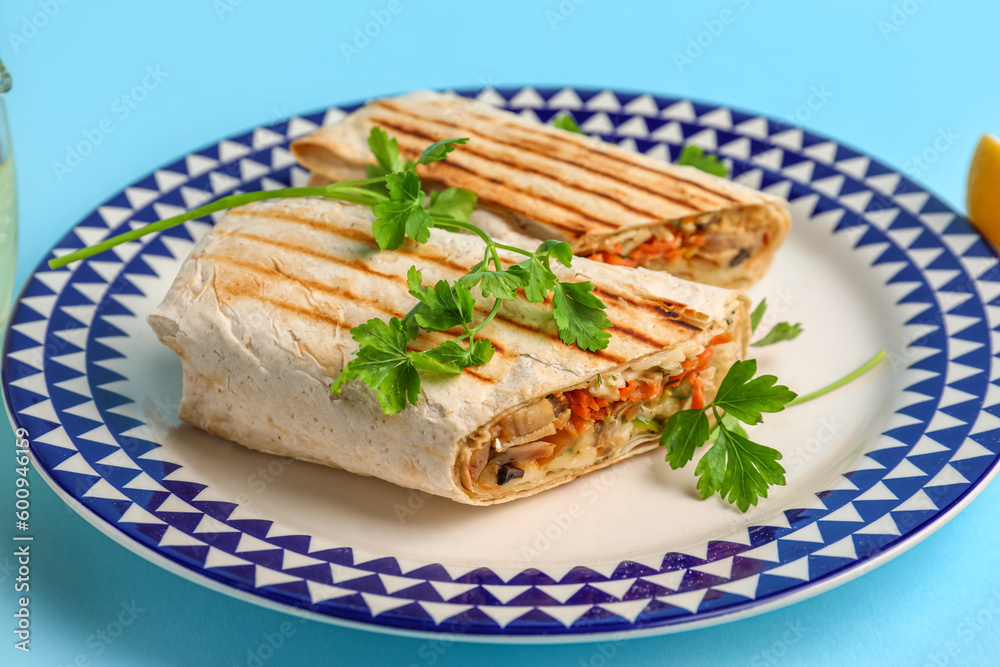 Plate with tasty shawarma and parsley on blue background