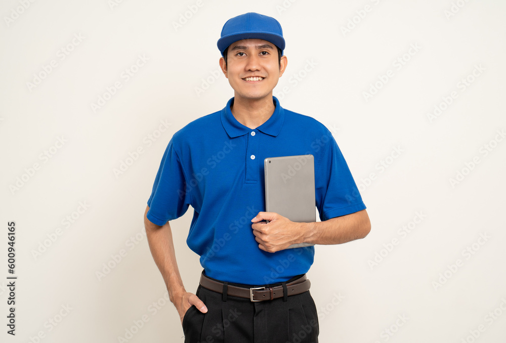 Asian man in blue uniform standing holding digital tablet computer on isolated white background. Male service worker with cell phone. Delivery courier shipping service Asian man in blue uniform standing holding digital tablet computer on isolated white background. Male service worker with cell phone. Delivery courier shipping service