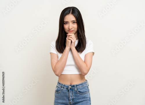 Beautiful smiling happy young asian woman age around 25 in white shirt. Charming female lady standing pose on isolated white background. Asian cute people looking camera confident with backdrop. © Chanakon