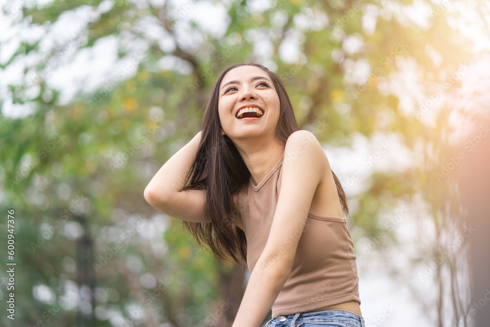 Happy feeling of Beautiful Young Woman smiling outdoor in sunlight. Pretty attractive face of female and beautiful smile. She is positive thinking and successful.