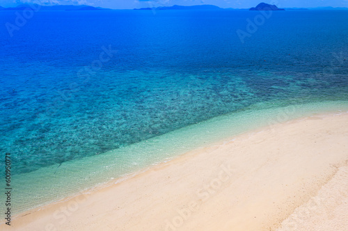 Fototapeta Naklejka Na Ścianę i Meble -  Aerial view beach sand background for summer vacation concept. Beach nature and summer seawater with sunlight light sandy beach Sparkling sea water contrast with the blue sky.