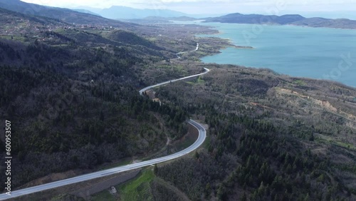 Road by the lake. Flying over lake Plastira in central Greece on a spring afternoon | 4K photo