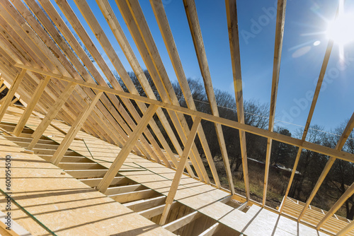 Construction framework timber truss framed building is currently being constructed with rafters, roof beams wooden joists as part of construction framework