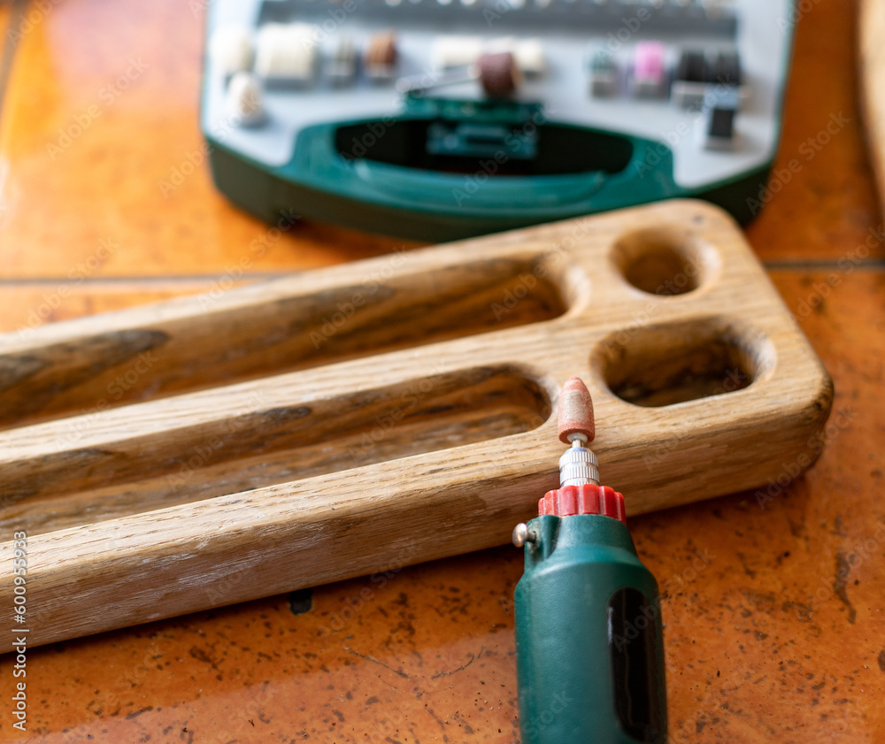 Naklejka premium box with accessories for processing and engraving next to an electric tool.