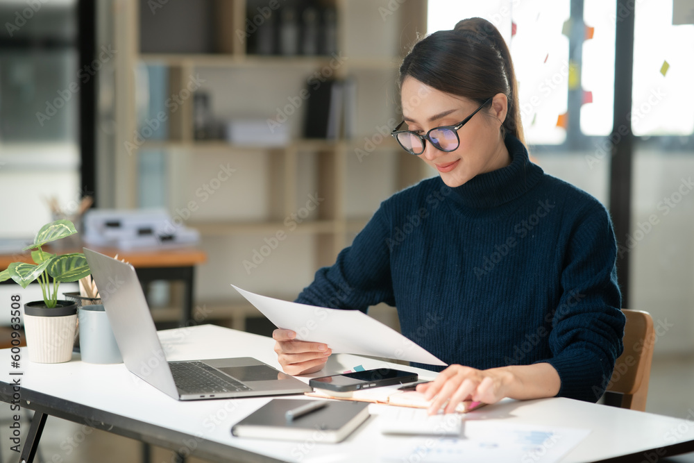 Asian businesswoman sitting and working about documents at the office Asian businesswoman sitting and working about documents at the office