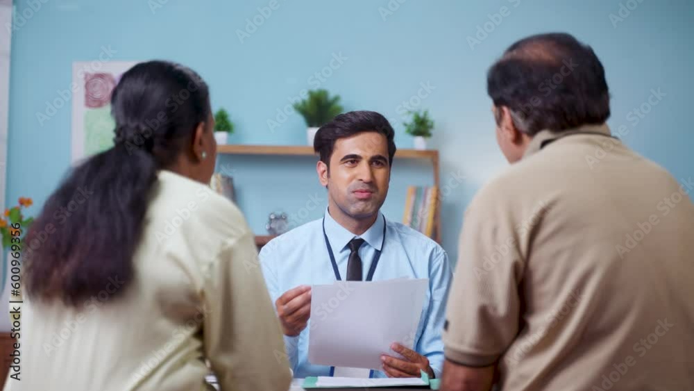 Shoulder shot, indian banker explaining about future investment plans or pension scheme offer to senio couple - concept of financial adviser, real-estate agent and consultant Shoulder shot, indian banker explaining about future investment plans or pension scheme offer to senio couple - concept of financial adviser, real-estate agent and consultant
