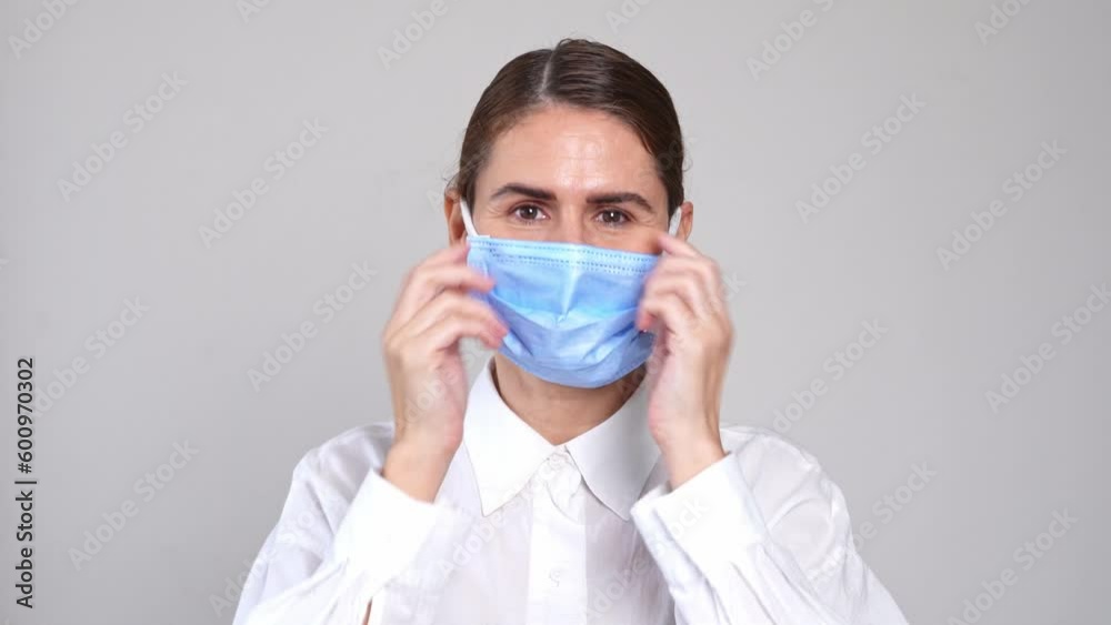 Beautiful healthy woman wear medical face mask on over white background. Middle aged put on protective face mask prevention during flu virus outbreak, epidemic and infectious diseases. COVID-19 Beautiful healthy woman wear medical face mask on over white background. Middle aged put on protective face mask prevention during flu virus outbreak, epidemic and infectious diseases. COVID-19