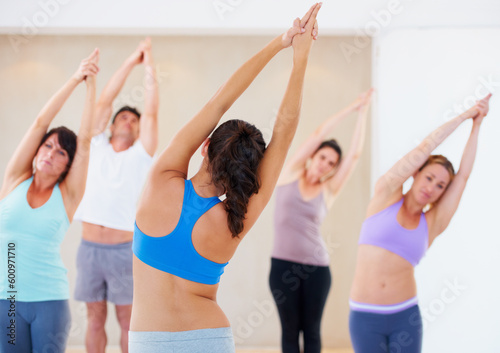 Fototapeta Naklejka Na Ścianę i Meble -  Woman, yoga and instructor in class for fitness, exercise or stretching workout together in healthy wellness. Female yogi coach, mentor or personal trainer with group in warm up arm stretch at gym