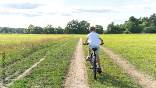 a boy learns to ride a bike in the park