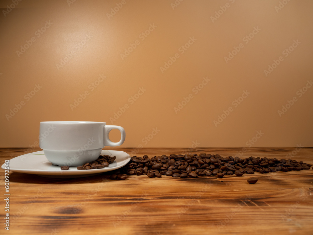 Obraz premium Cup of coffee and roasted coffee beans on a wooden background.