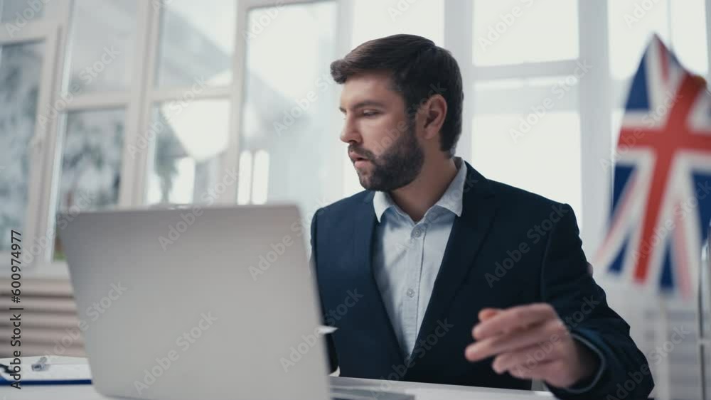 UK visa officer checking citizens documents, updating database on laptop UK visa officer checking citizens documents, updating database on laptop