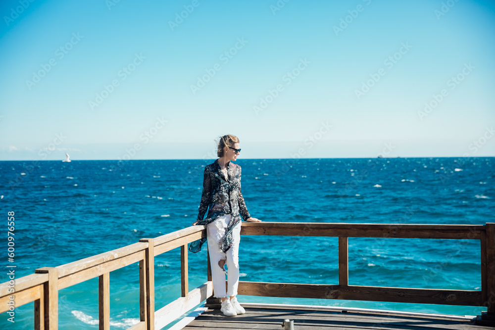 a woman stands at the railing on the sea voyage boat trip
