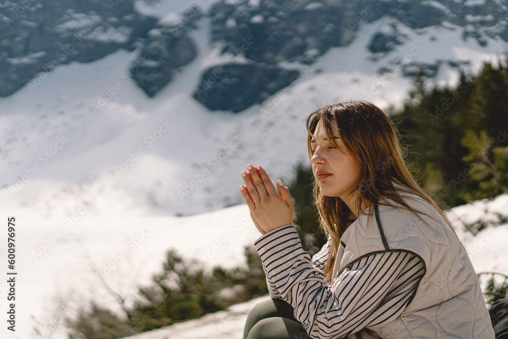 Woman closed her eyes, praying near the mountain. Hands folded in prayer concept for faith, spirituality and religion. Peace, hope, dreams concept Woman closed her eyes, praying near the mountain. Hands folded in prayer concept for faith, spirituality and religion. Peace, hope, dreams concept