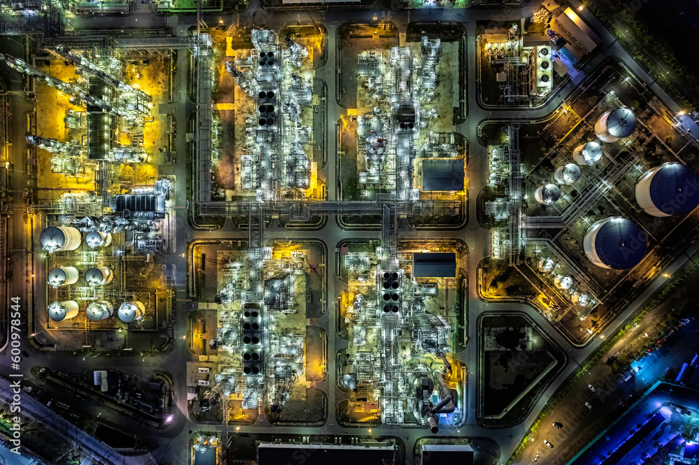 Aerial top view oil refinery and gas petrochemical industry with storage tanks steel pipeline area at twilight.
