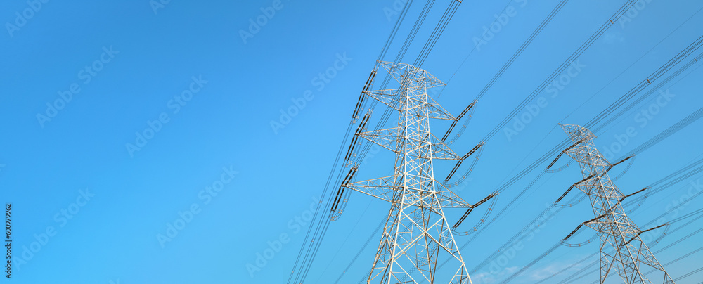 Looking up steel power pylon construction with high voltage cables against blue sky. Wide banner for electric energy industry with space for text on left side