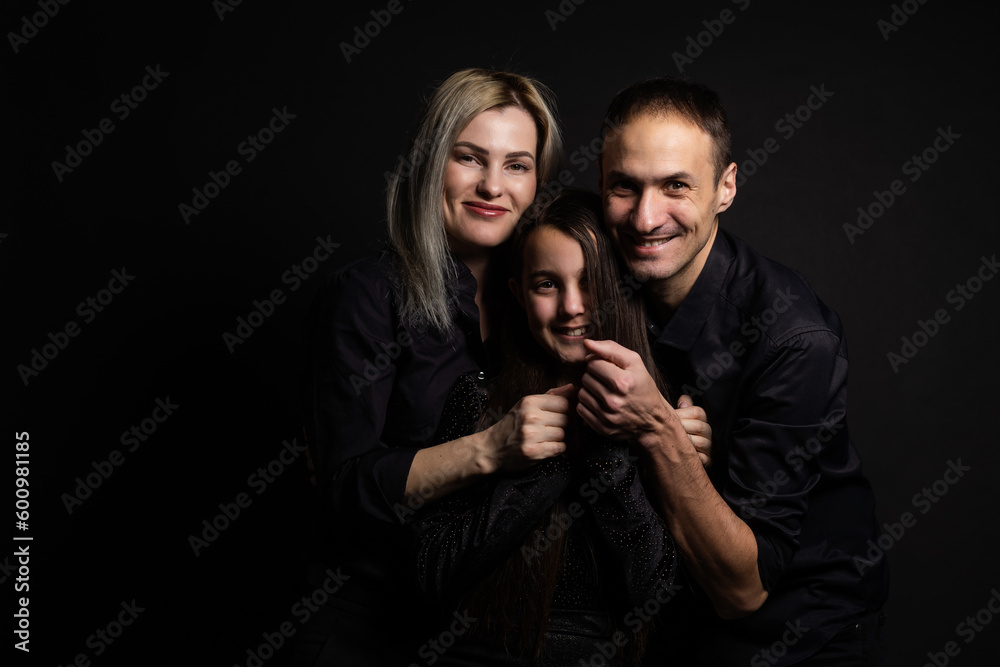 Happy young family with one child having fun together isolated on black. Happy young family with one child having fun together isolated on black.