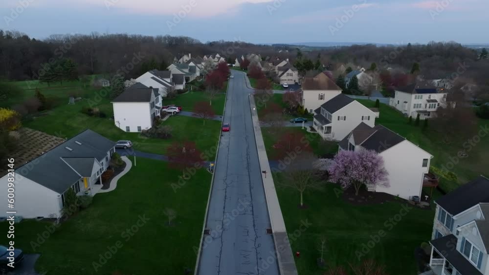 American neighborhood at dusk. Aerial establishing shot during blue hour. Dolly forward over street in residential suburb. American neighborhood at dusk. Aerial establishing shot during blue hour. Dolly forward over street in residential suburb.