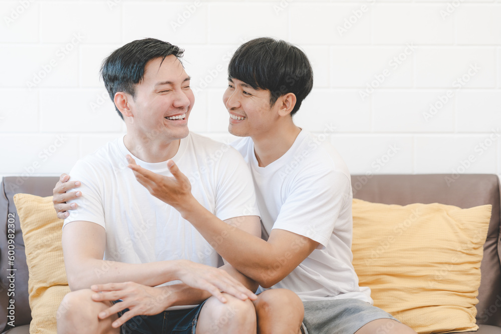Happy Asian gay couple hug together on sofa. Asian LGBT couple embracing together at home. Diversity of LGBT relationships. A gay couple concept. LGBT multi relationship. Happy Asian gay couple hug together on sofa. Asian LGBT couple embracing together at home. Diversity of LGBT relationships. A gay couple concept. LGBT multi relationship.