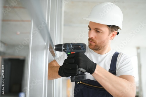 man fasten metal profile frame to the wall for draywall bulkhead photo