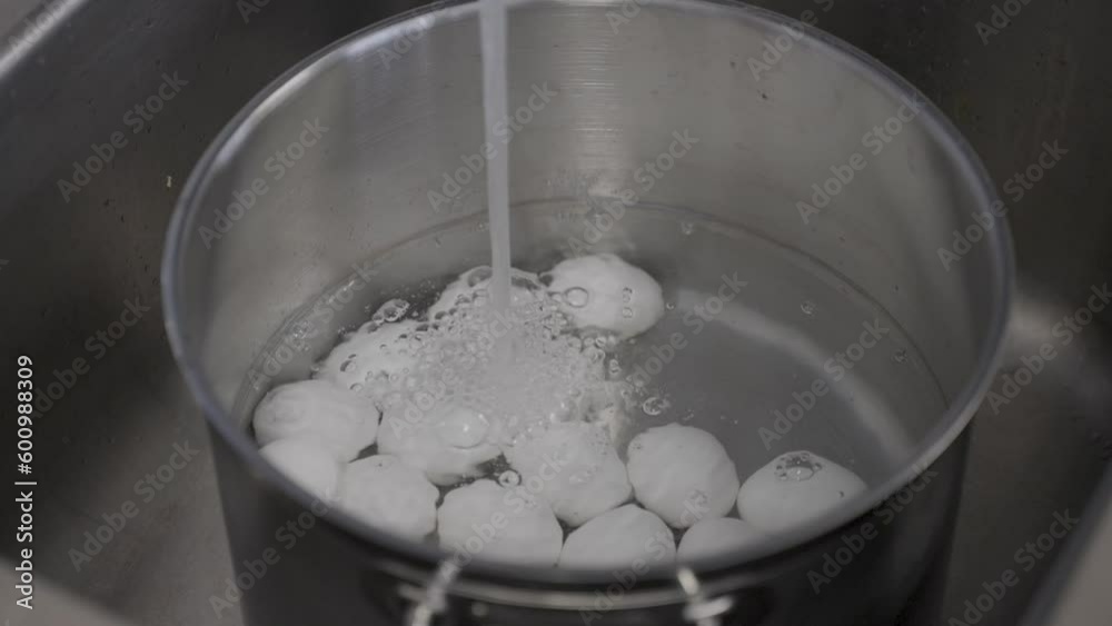 Water filling up a cooking pot filled with eggs ready to boil. Water filling up a cooking pot filled with eggs ready to boil.