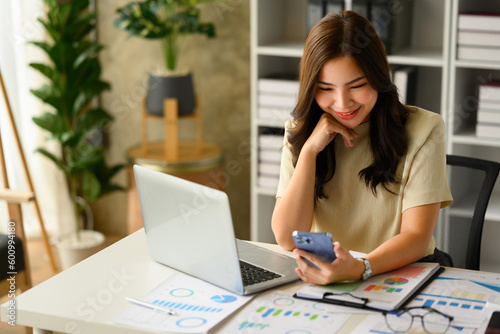 Attractive female investment advisor using smartphones, chatting with client online or giving internet consultation to customer