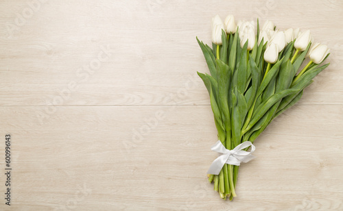White tulip bouquet on wooden background  top view