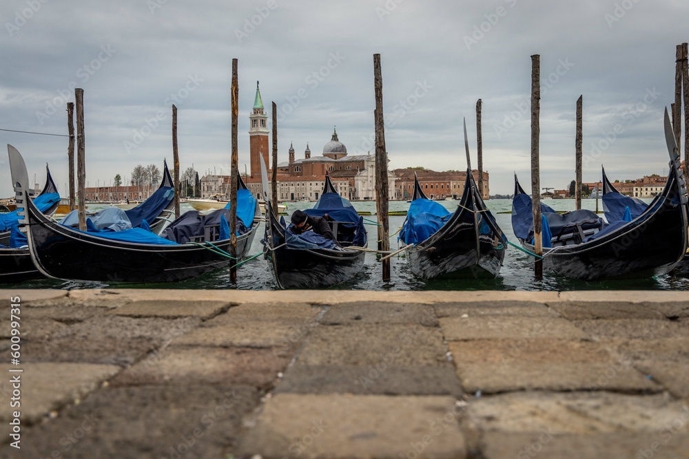 Gondolas in Venice in a cloudy day, with church in the background, Italy