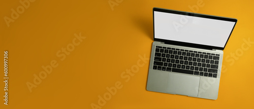 Laptop computer with white empty screen on yellow background with copy space for your advertise text