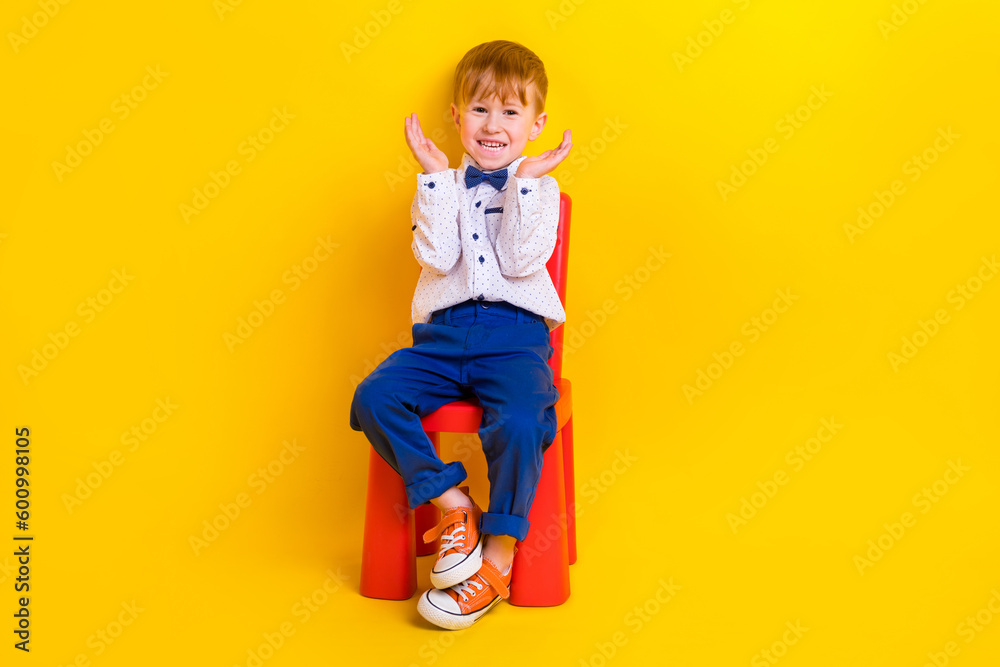 Photo of laughing sweet kid boy sitting kindergarten chair enjoying birthday party surprise isolated shine color background Photo of laughing sweet kid boy sitting kindergarten chair enjoying birthday party surprise isolated shine color background