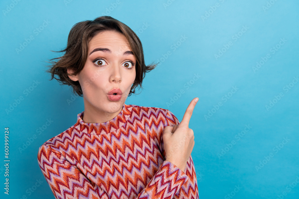Photo of impressed funny lady wear striped top lips pouted plump pointing empty space isolated blue color background Photo of impressed funny lady wear striped top lips pouted plump pointing empty space isolated blue color background