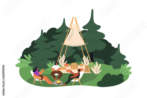 Tipi camping. Friends around fire, relaxing in nature at teepee. People talki...