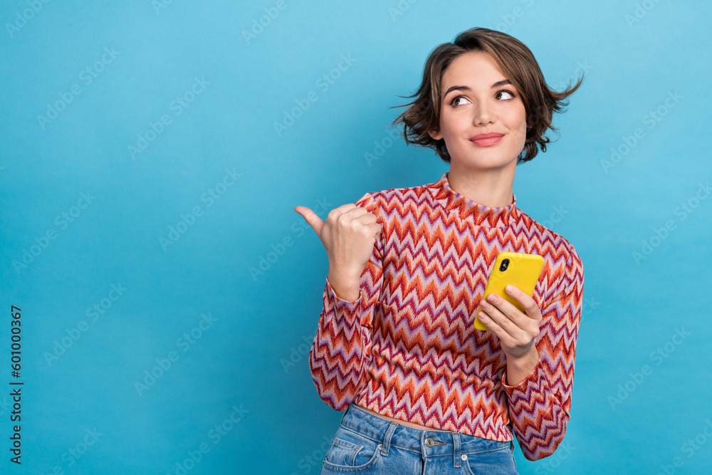 Photo of dreamy cute lady wear pink shirt chatting device pointing thumb empty space isolated blue color background - obrazy, fototapety, plakaty 
