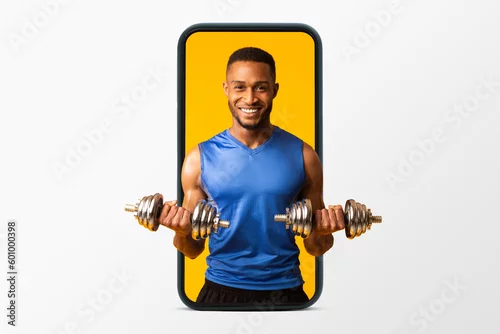 Obraz Happy millennial african american muscular guy in sportswear doing exercises with dumbbells