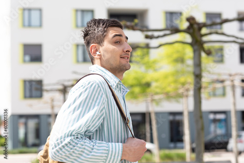 Portrait eines jungen Mannes aussen mit Tasche 
in der Stadt