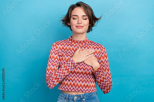 Photo of dreamy adorable woman dressed pink shirt closed eyes arms chest isolated blue color background