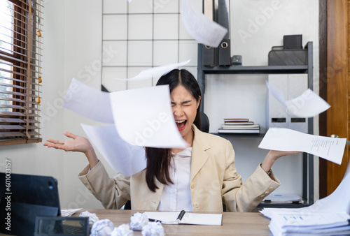 Businesswoman sitting with head in hands at desk covered crumpled papers. Office worker tired of too much difficult unproductive work. Stressed female entrepreneur has no idea what to do with problem