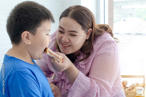 Overweigh mother coaxing her son to overeat, examples of bad eating habits, good health and body shape concept photo