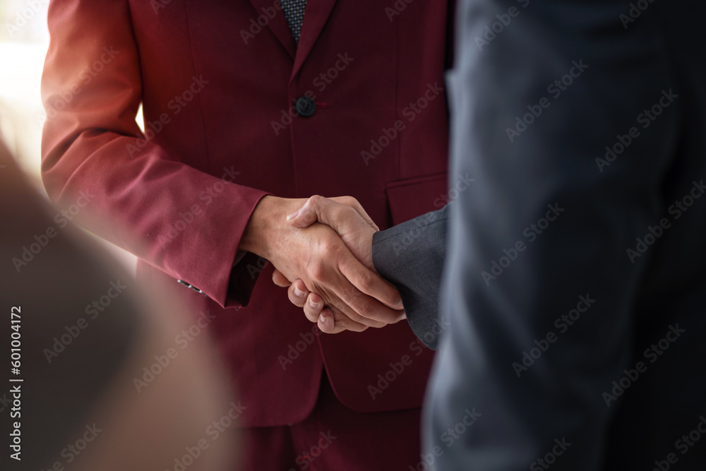 Young Indian businessman shaking hands with customer after reaching business deal Young Indian businessman shaking hands with customer after reaching business deal