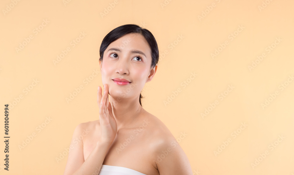 Beautiful girl asian model touching fresh glowing hydrated facial skin on beige background closeup. Beauty face young woman with natural makeup and healthy skin portrait. Skin care concept Beautiful girl asian model touching fresh glowing hydrated facial skin on beige background closeup. Beauty face young woman with natural makeup and healthy skin portrait. Skin care concept