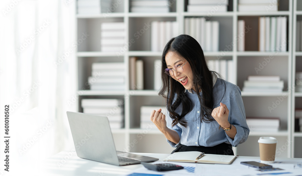 copy space, panorama ,banner Modern working lifestyle, asian businesswoman showing happy gesture of online business success on laptop and mobile phone using internet happily in office. copy space, panorama ,banner Modern working lifestyle, asian businesswoman showing happy gesture of online business success on laptop and mobile phone using internet happily in office.