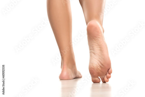 Back view of a beautifully cared female bare feet on a white studio background.