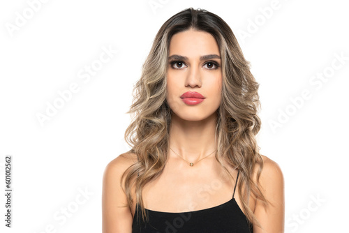 beautiful young serious women with makeup and long wavy hair on a white background.