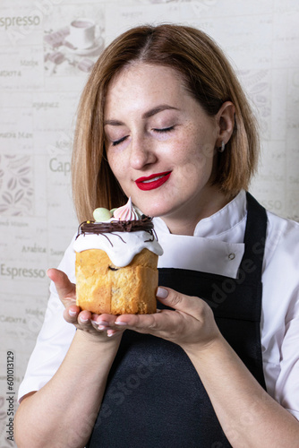 Portrait of a beautiful pastry chef woman with a cupcake in her hands
