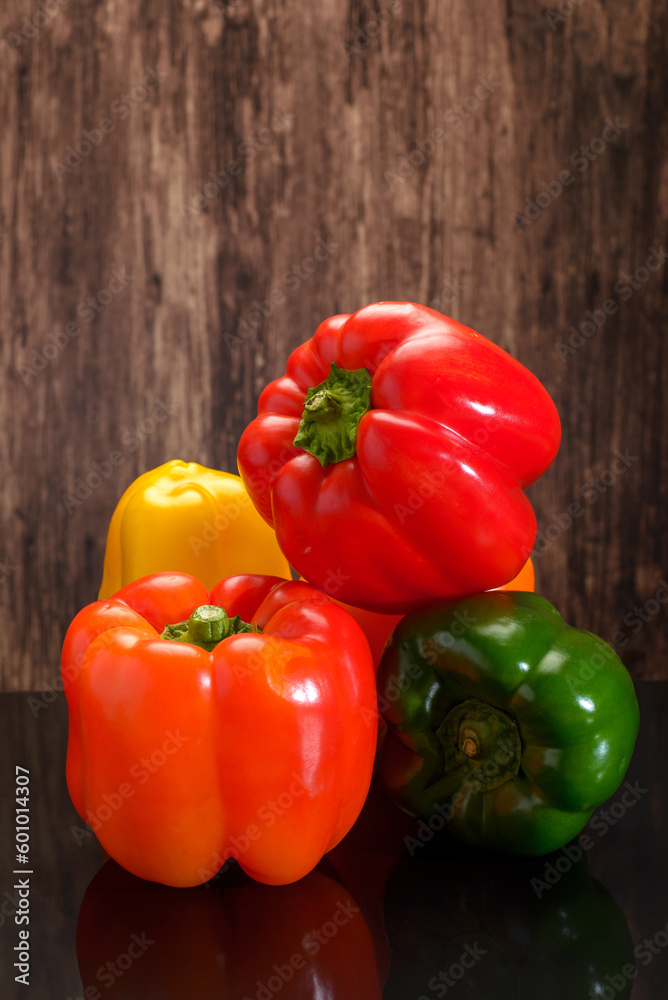 Group of peppers of different colors on a wooden table. Bell peppers of different colors. Group of peppers of different colors on a wooden table. Bell peppers of different colors.