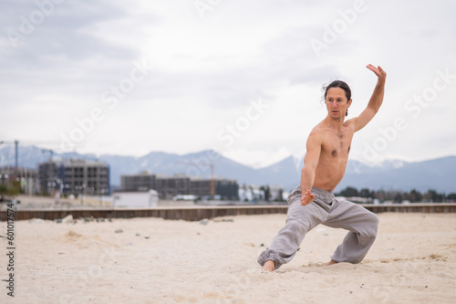 Fototapeta Naklejka Na Ścianę i Meble -  Caucasian man practices martial arts outdoors. balance and meditation.
