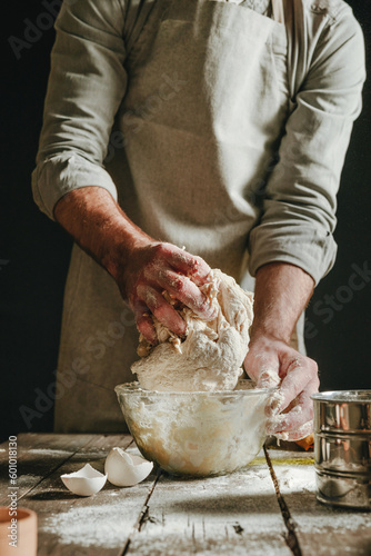 Photography Unrecognizable man in an apron kneading the dough