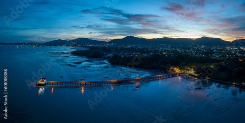 aerial photography cloud above Palai pier at beautiful sunset..Palai pier is next to Chalong pier..fishing boats parking on the beach..colorful cloud above the mountain range background..