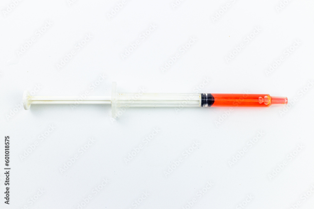 Fototapeta premium Red plastic syringe on a white background. Isolated on white.
