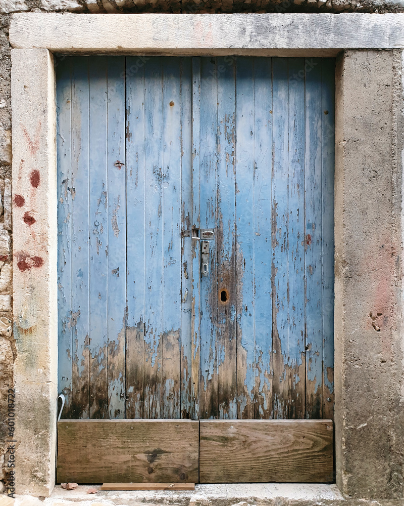 old blue wooden door against stone brick wall