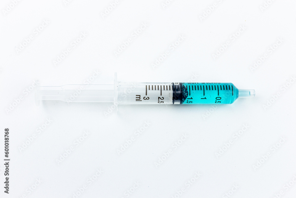 syringe with blue liquid inside on a white background. close-up of a syringe syringe with blue liquid inside on a white background. close-up of a syringe